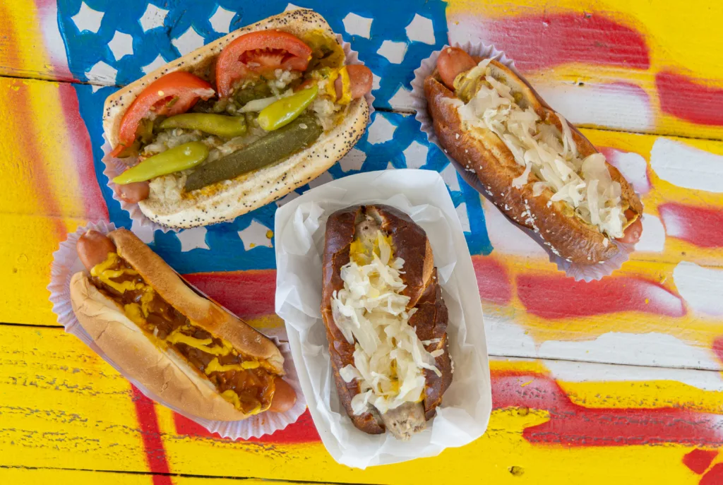 Three hot dogs with assorted vegetable toppings