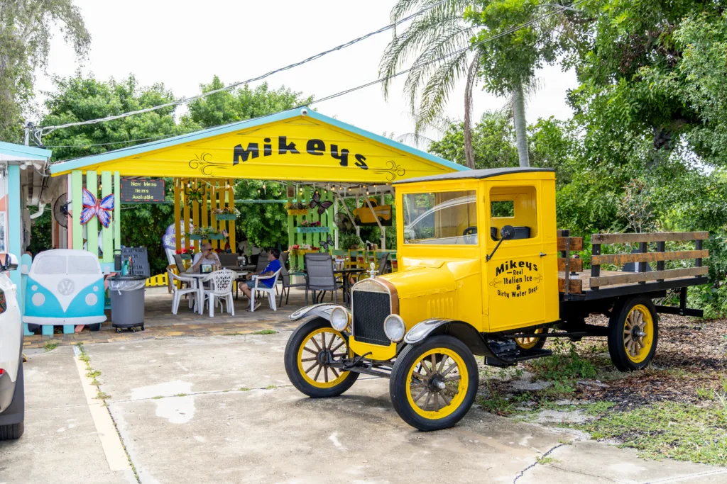 Mikey's yellow food stand with a yellow vintage-style delivery vehicle