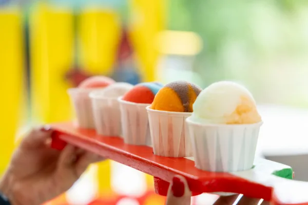 Colorful Italian ice scoops lined up in white paper cups